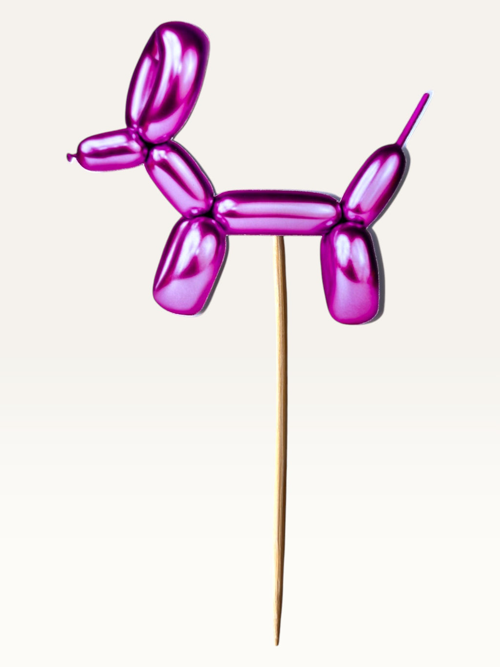 Paper Party Studio metallic pink balloon dog cake topper made of thick paper on a bamboo stick.