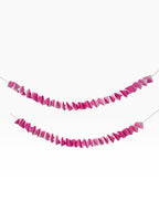 Paper Party Studio pink ombre accordion streamer garland made of folded cardstock.