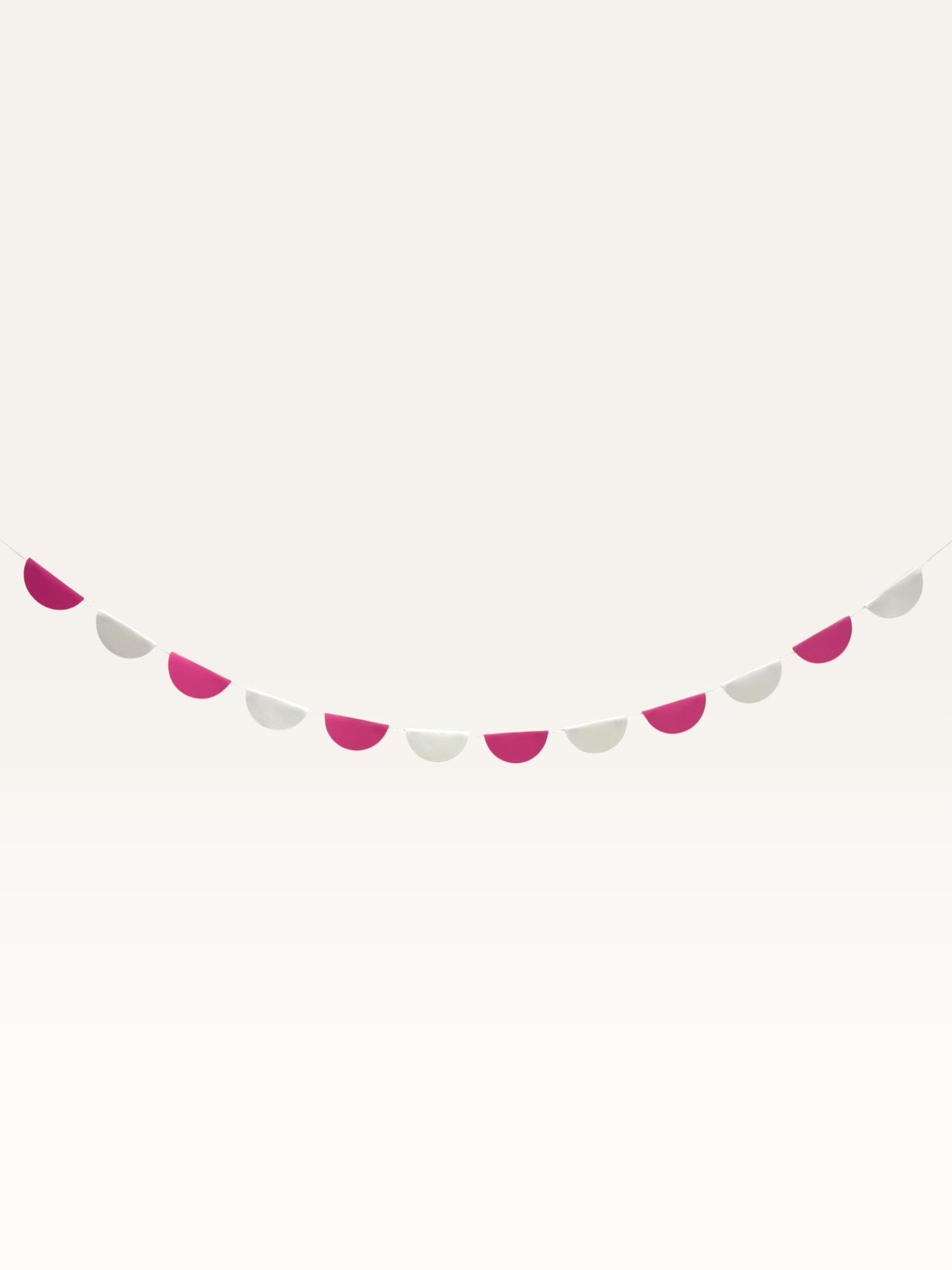 Paper Party Studio pink and white paper scallop garland hanging as a decorative wall banner for parties and nurseries.