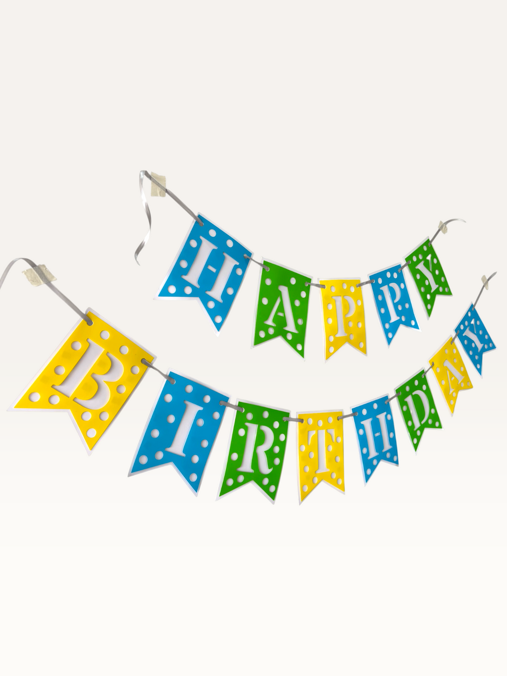 Paper Party Studio Happy Birthday banner with blue, green, and yellow polka dot swallowtail flags and white letters.