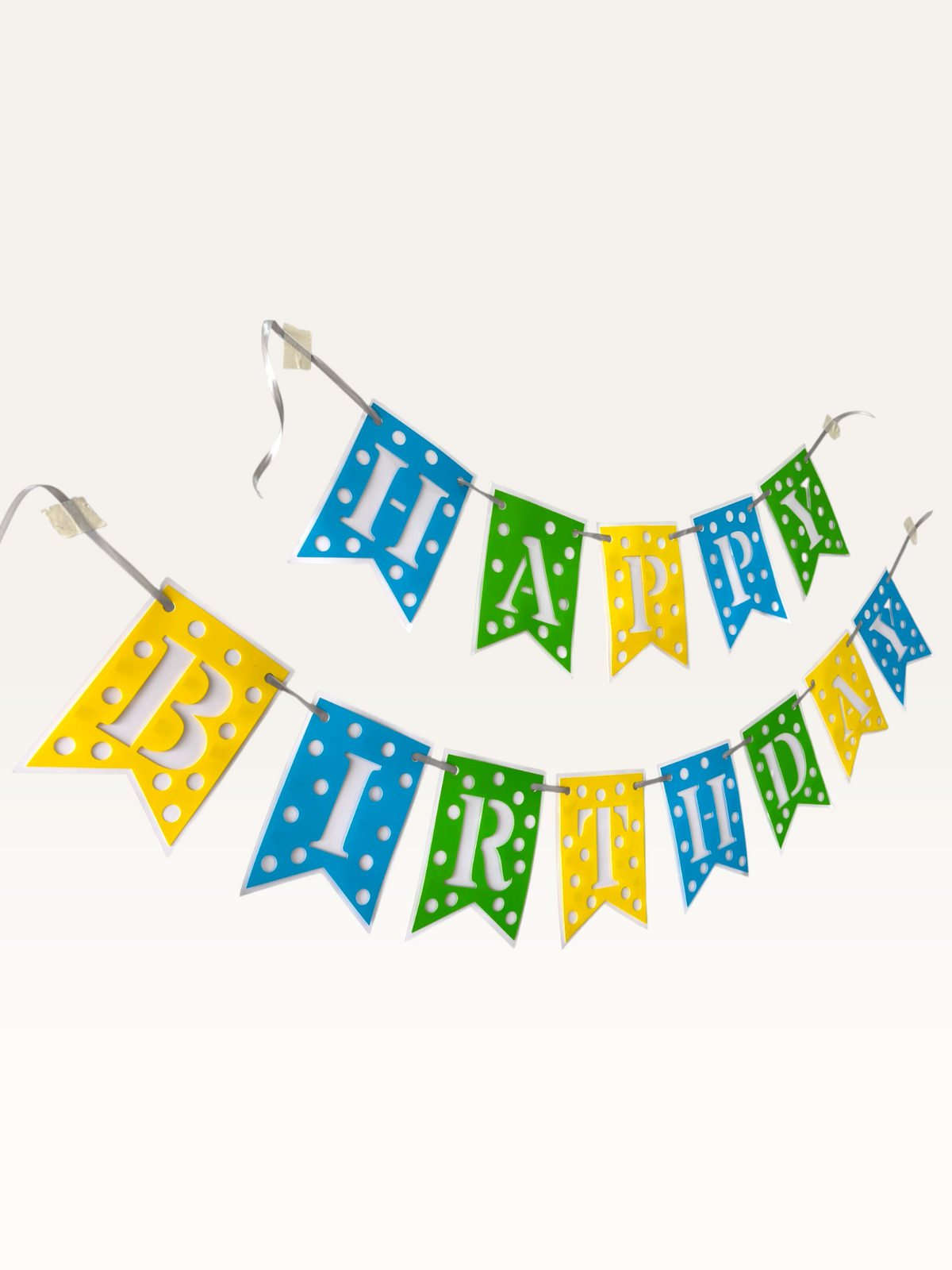 Paper Party Studio Happy Birthday banner with blue, green, and yellow polka dot swallowtail flags and white letters.