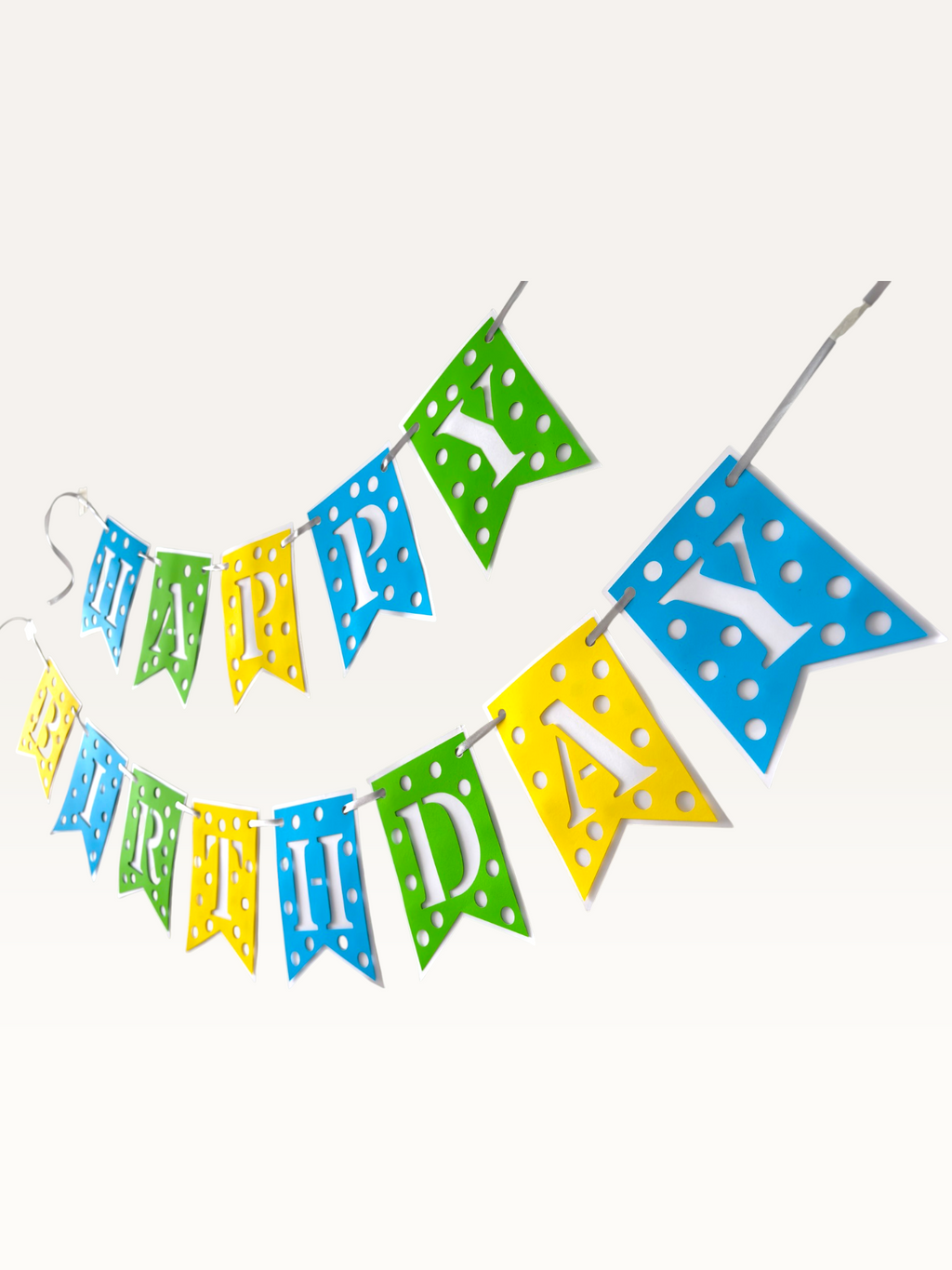Paper Party Studio Happy Birthday banner with blue, green, and yellow polka dot swallowtail flags and white letters.