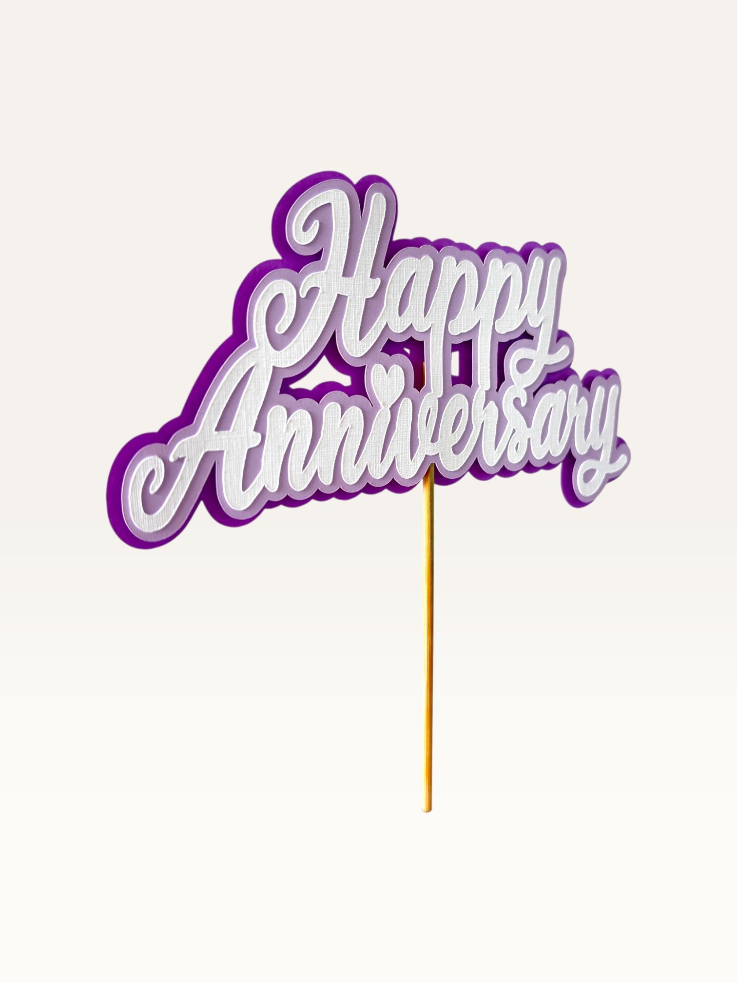 Paper Party Studio layered purple and white cardstock Happy Anniversary cake topper with heart detail on a wooden pick