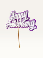 Paper Party Studio layered purple and white Happy Anniversary cake topper with script lettering and heart detail.