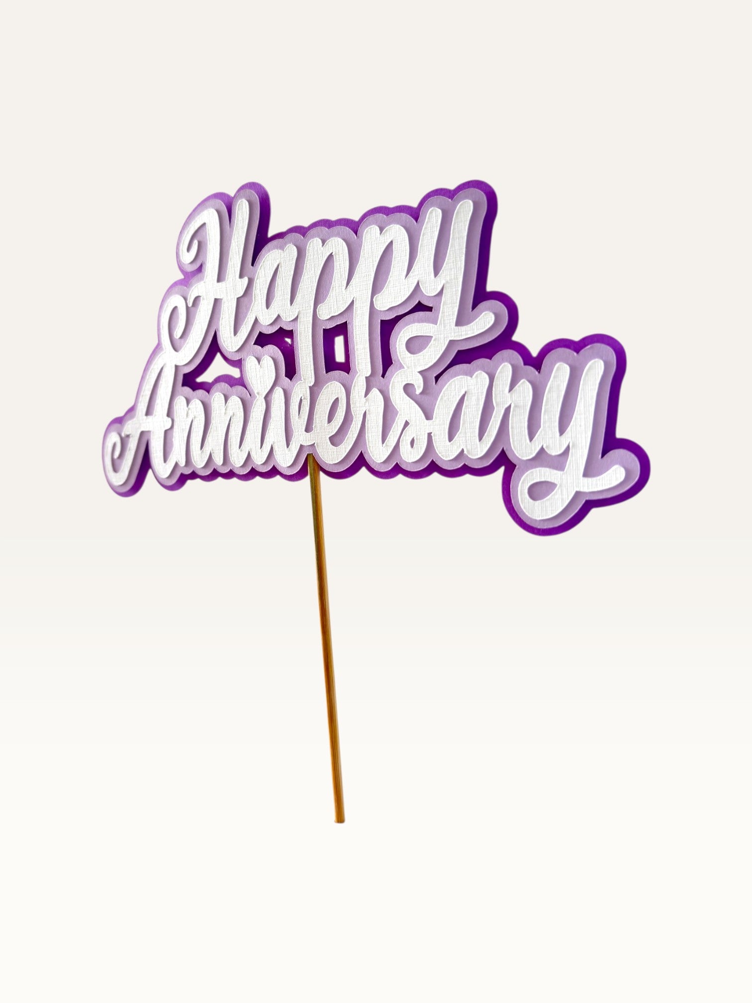 Paper Party Studio layered purple and white Happy Anniversary cake topper with script lettering and heart detail.
