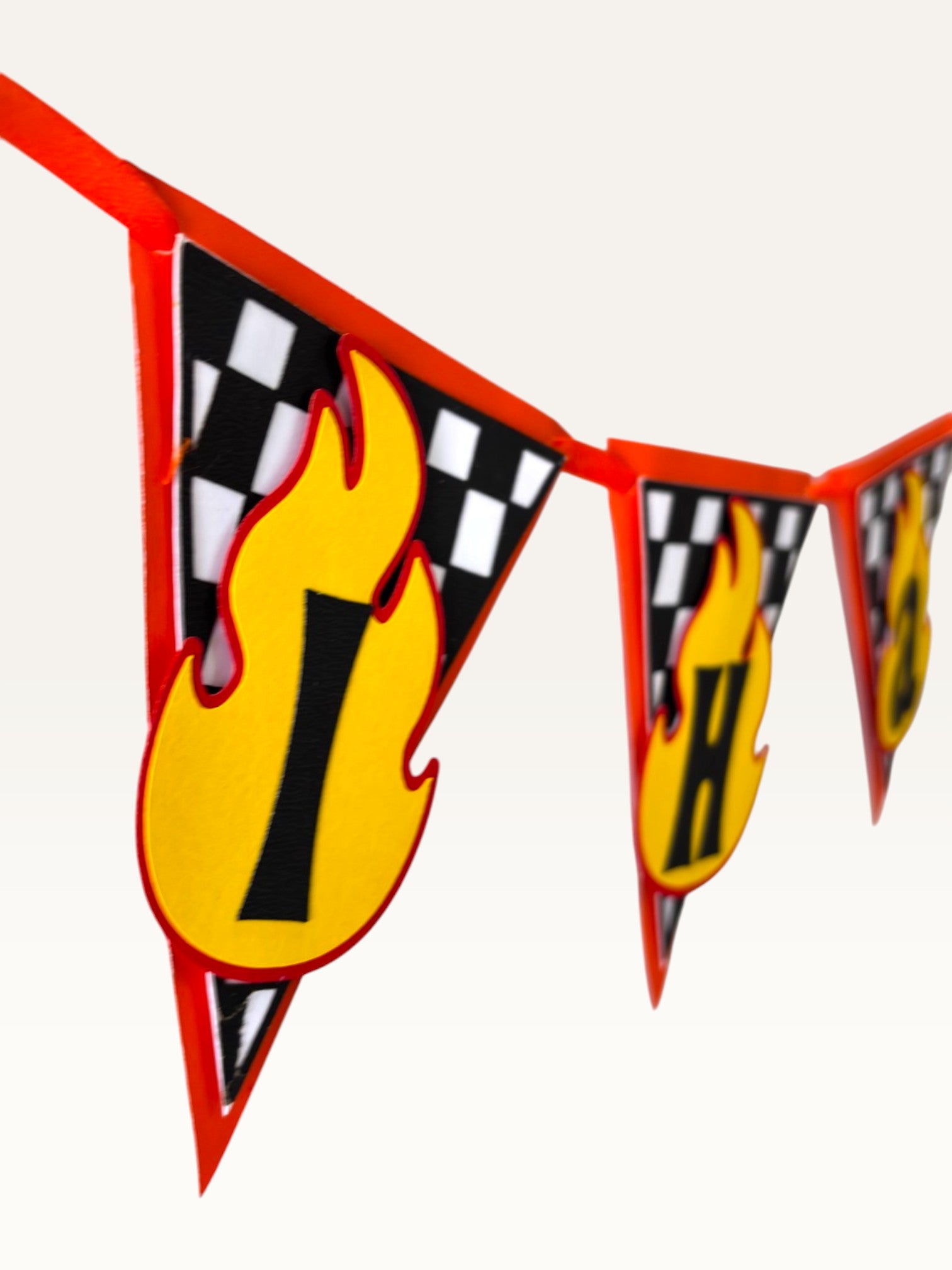 Paper Party Studio personalised racing name banner featuring checkered flags and yellow flame letters on red string