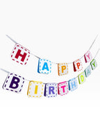 Paper Party Studio rainbow paper birthday banner with dashed border detail on white flags.