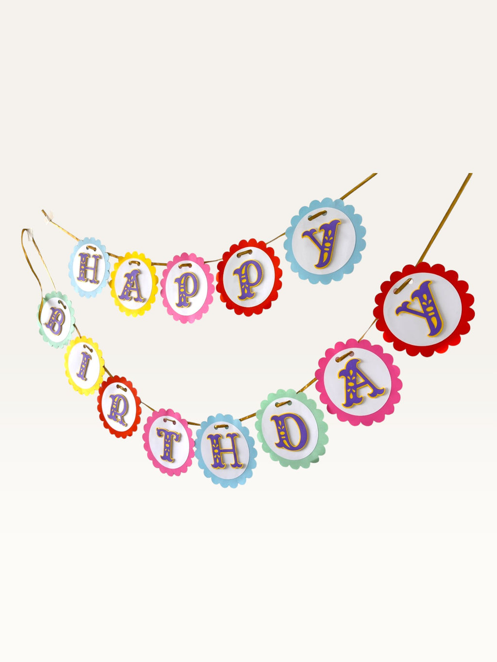 Paper Party Studio rainbow scalloped Happy Birthday banner with purple and gold lettering on a gold ribbon.