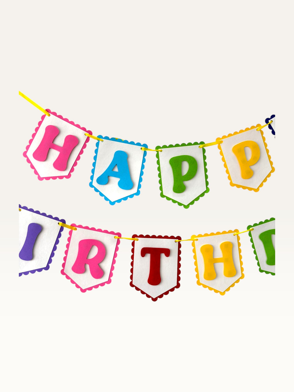 Paper Party Studio rainbow Happy Birthday banner with scalloped white paper flags on a bright yellow cord.