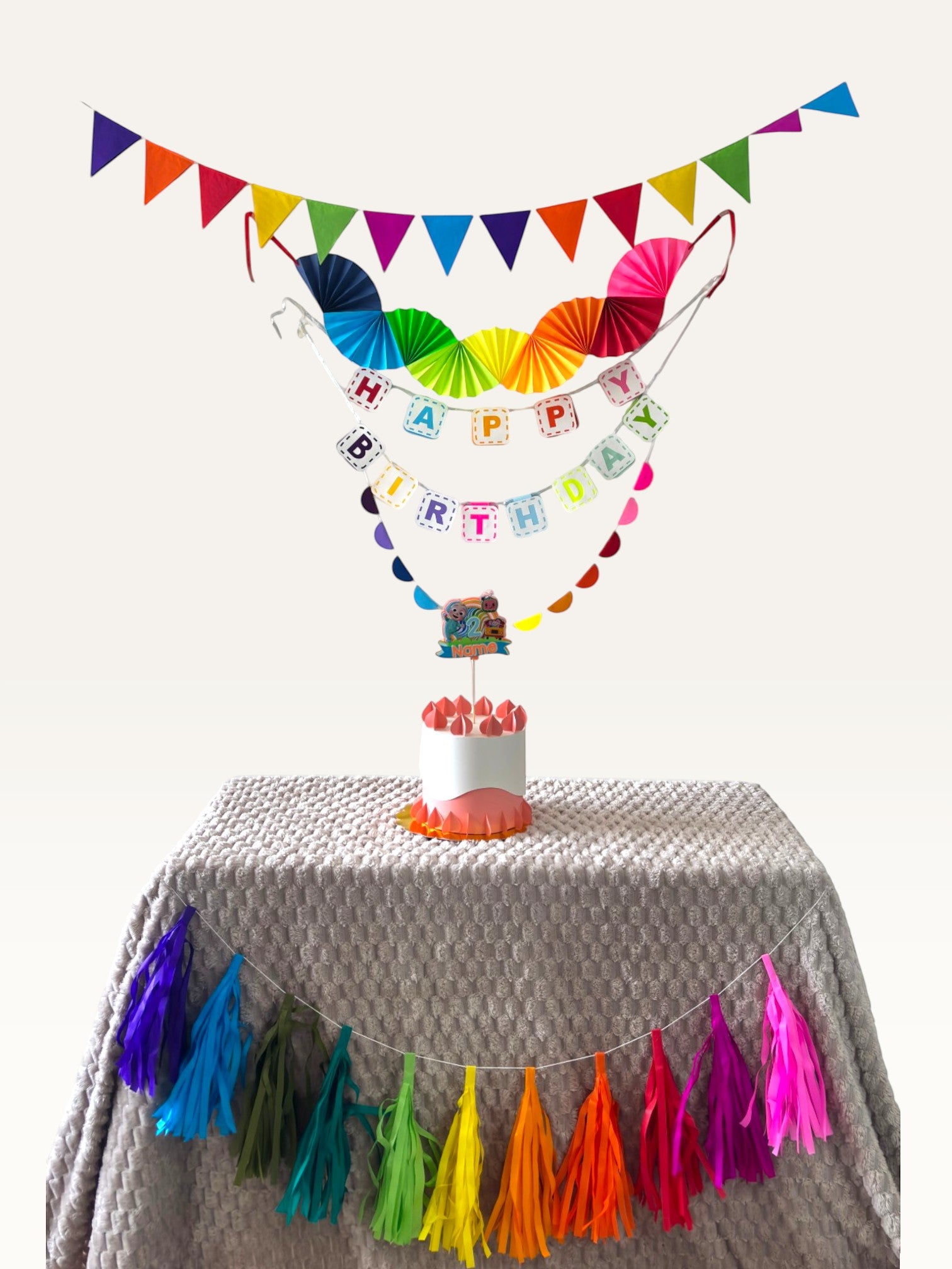 Paper Party Studio rainbow birthday decoration set with paper fans, bunting, banner, tassels, and personalised topper.