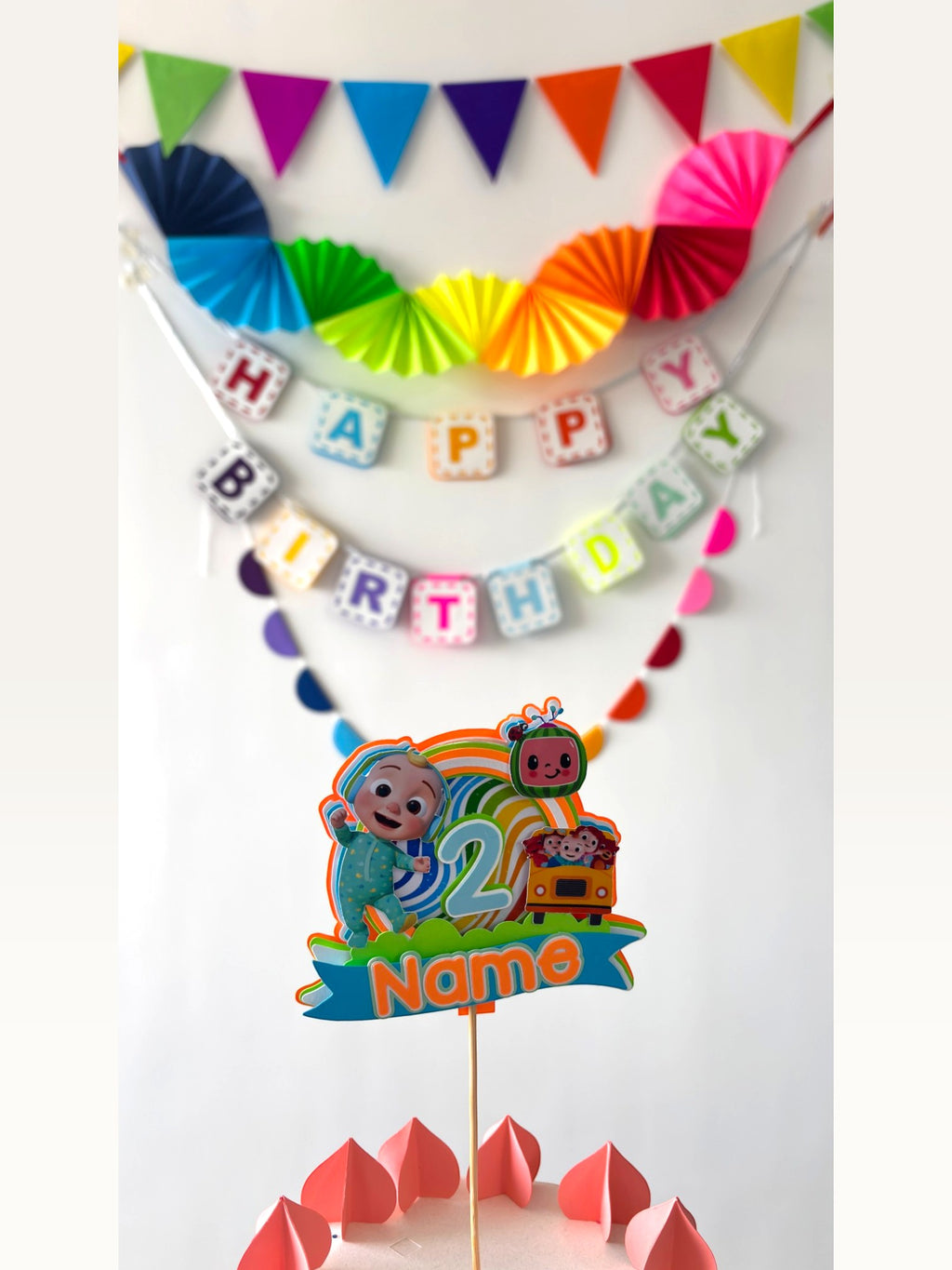 Paper Party Studio personalised rainbow birthday decoration set with Cocomelon cake topper and wall bunting