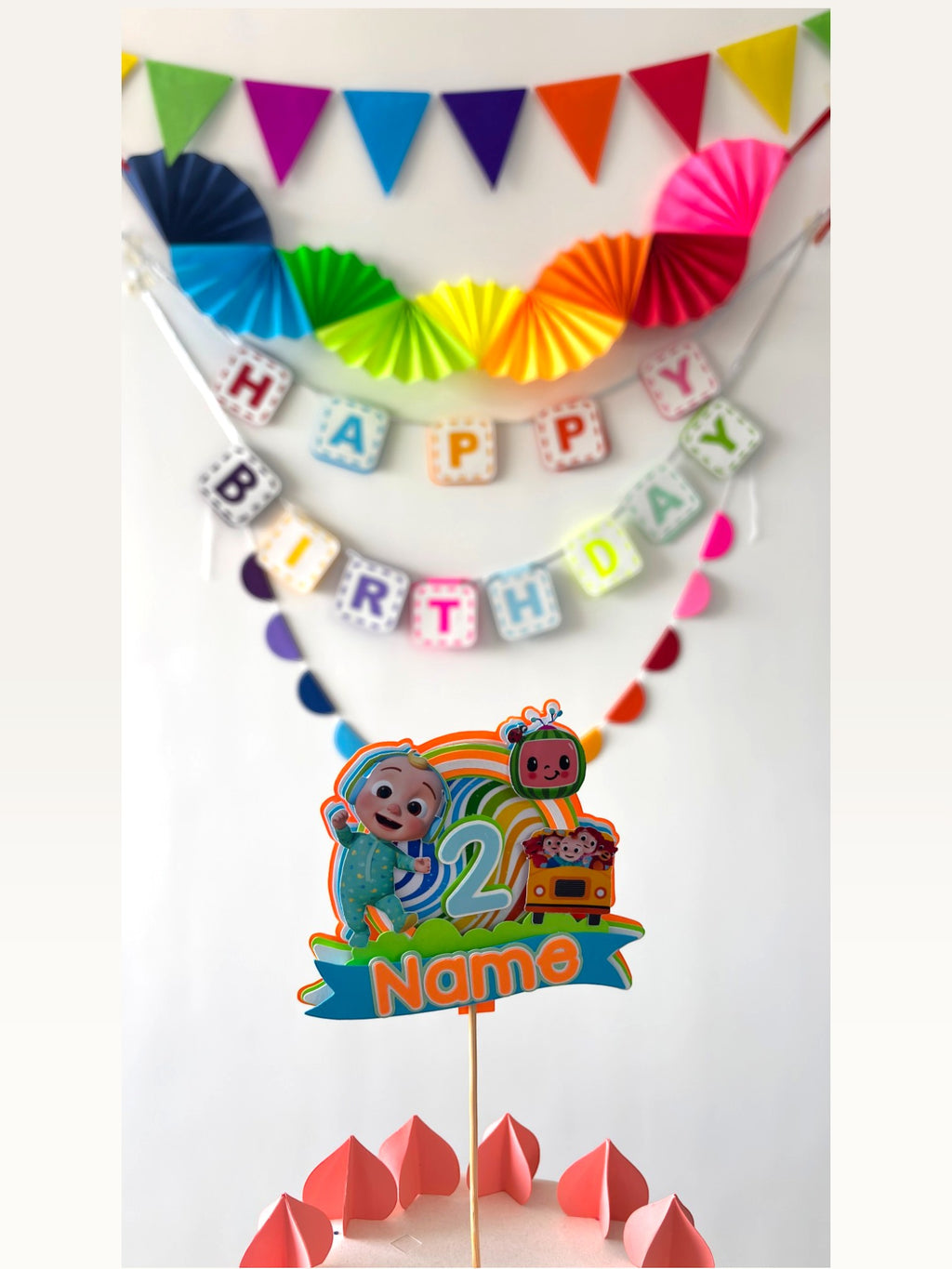 Paper Party Studio rainbow birthday decoration set with personalised Cocomelon cake topper and wall bunting