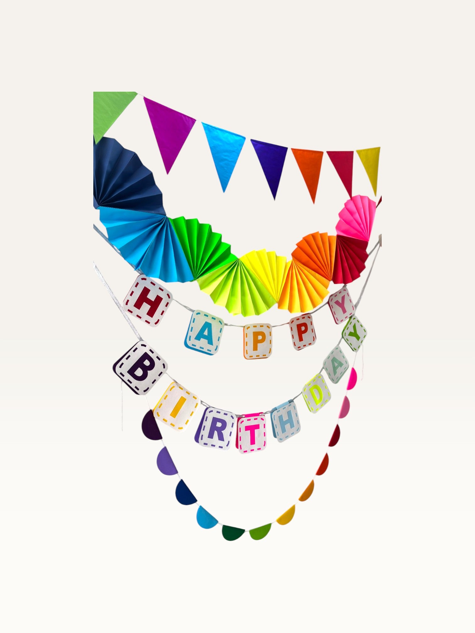 Paper Party Studio rainbow birthday decoration set featuring a Happy Birthday banner, paper fans, and bunting.