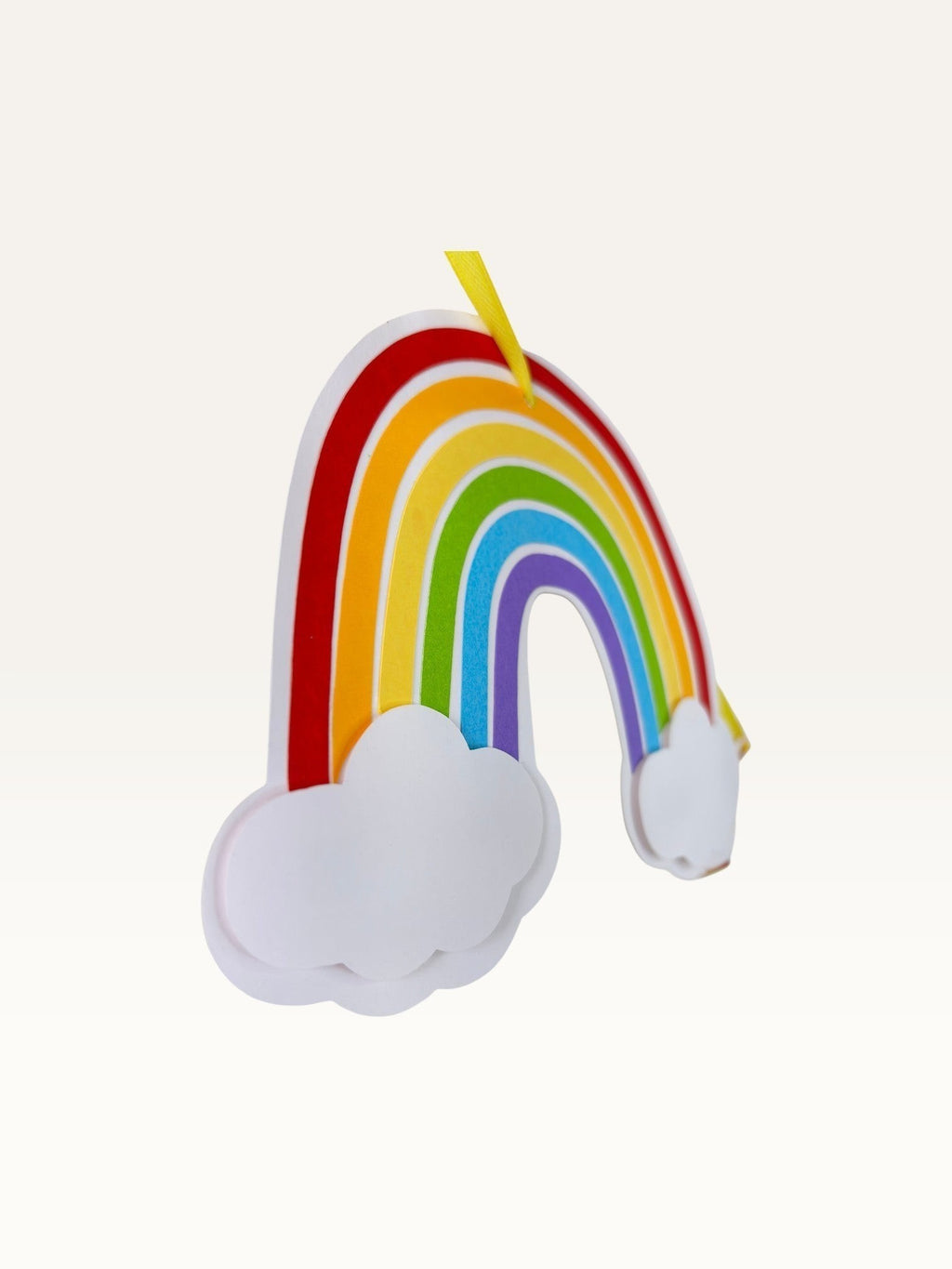 Paper Party Studio rainbow and cloud cardstock accent piece for a birthday banner hanging on a yellow ribbon.
