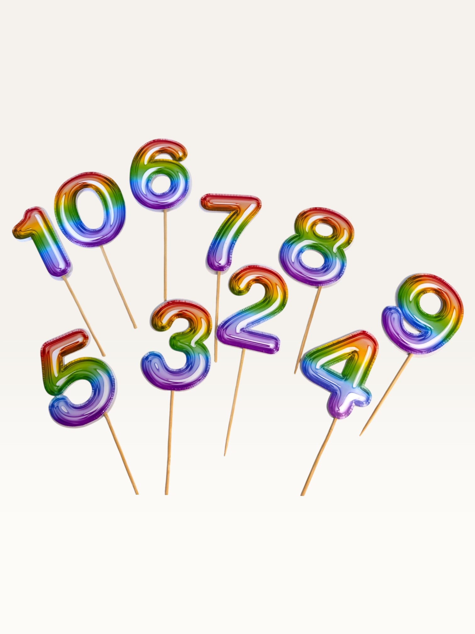 Paper Party Studio rainbow foil number cake toppers on bamboo sticks for birthday celebrations.
