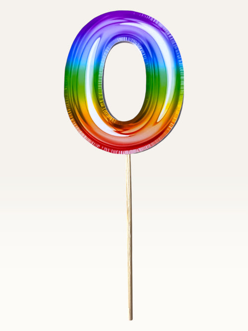 Paper Party Studio rainbow foil number zero cupcake topper on a bamboo stick with double-sided metallic finish.