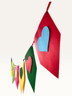 Paper Party Studio rainbow heart bunting made of layered cardstock for birthday and party decorations.