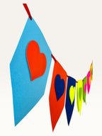 Paper Party Studio rainbow heart bunting made of layered cardstock flags in vibrant colours for party decoration.