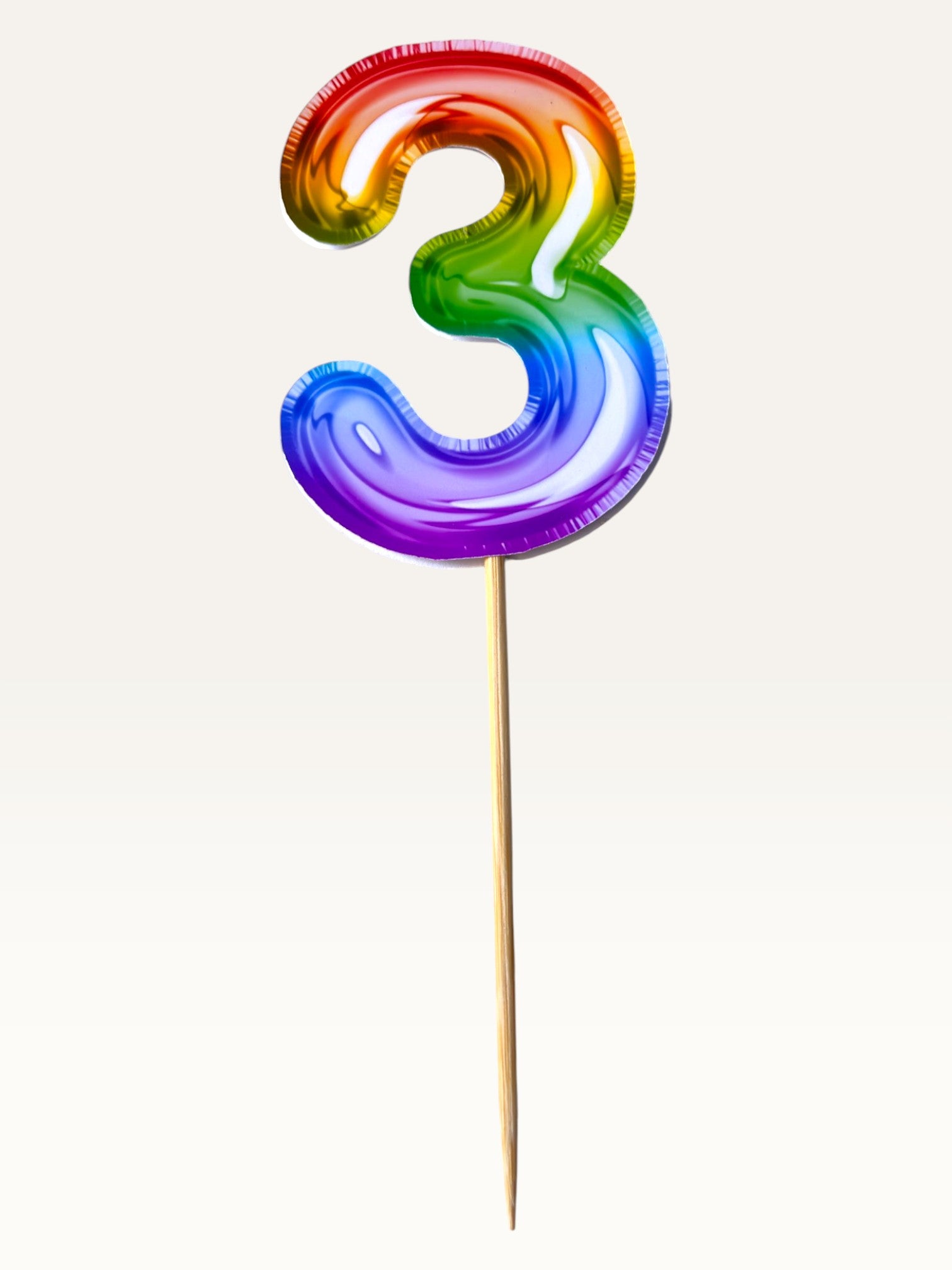 Paper Party Studio rainbow foil number 3 cake topper on a bamboo stick for birthday celebrations.