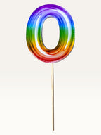 Paper Party Studio rainbow foil number zero cake topper on a bamboo stick for birthday celebrations.