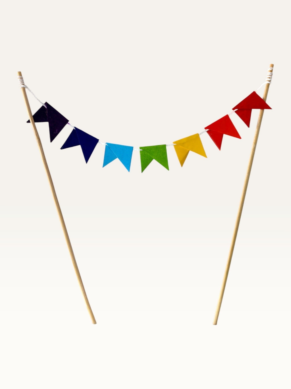 Paper Party Studio rainbow pennant cake topper with colorful paper triangle flags on two bamboo sticks.