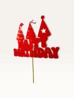 Paper Party Studio red Happy Birthday cake topper with three party hat cut-outs on a wooden pick.
