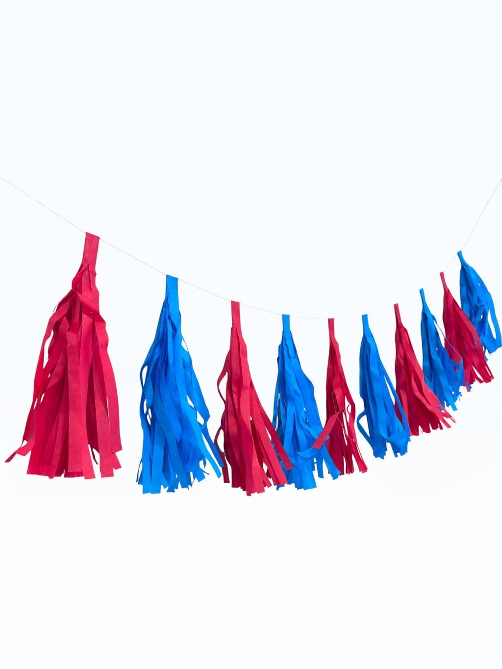 Paper Party Studio red and blue tissue paper tassel garland for party decorations and birthday backdrops.