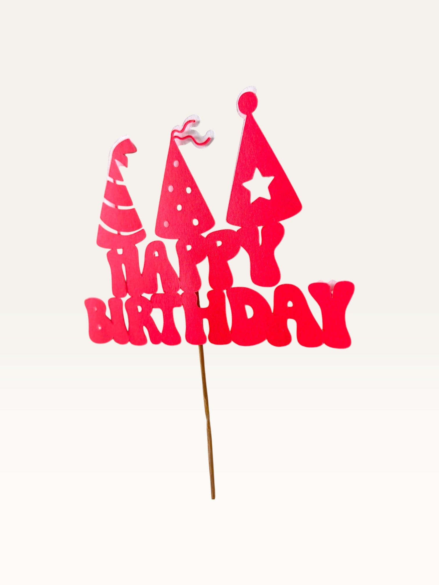Paper Party Studio red Happy Birthday cake topper with three party hat cut-outs on a wooden pick.