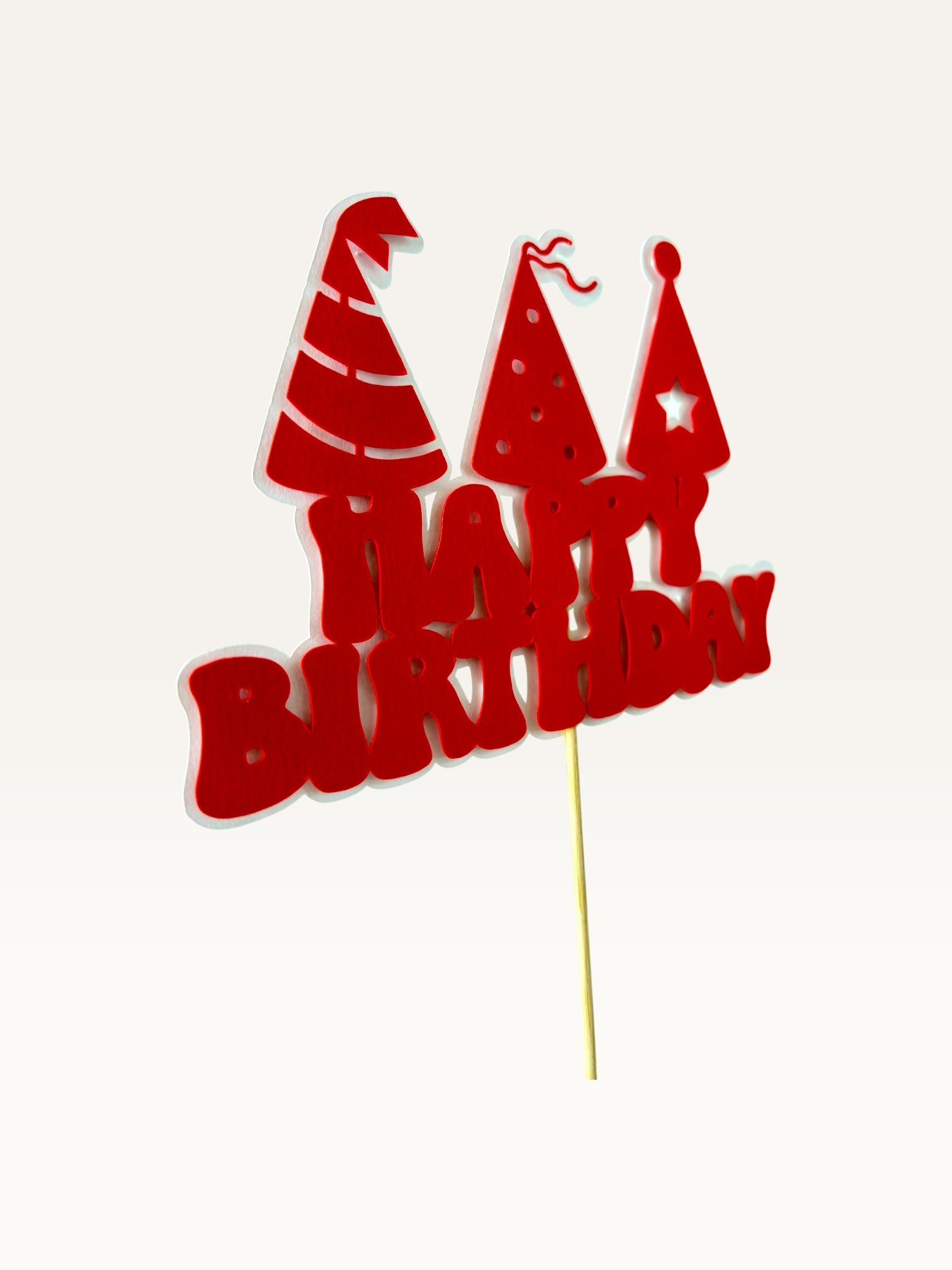 Paper Party Studio red Happy Birthday cake topper with three party hat cut-outs on a wooden pick.