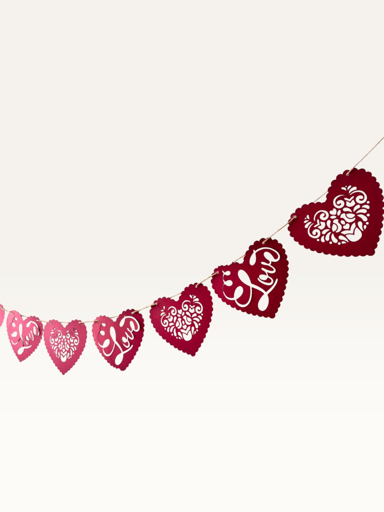 Paper Party Studio red heart bunting with scalloped edges, floral cut-outs, and cursive Love text for romantic decor.