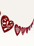 Paper Party Studio red heart bunting with scalloped edges, floral cut-outs, and cursive Love text for romantic decor.