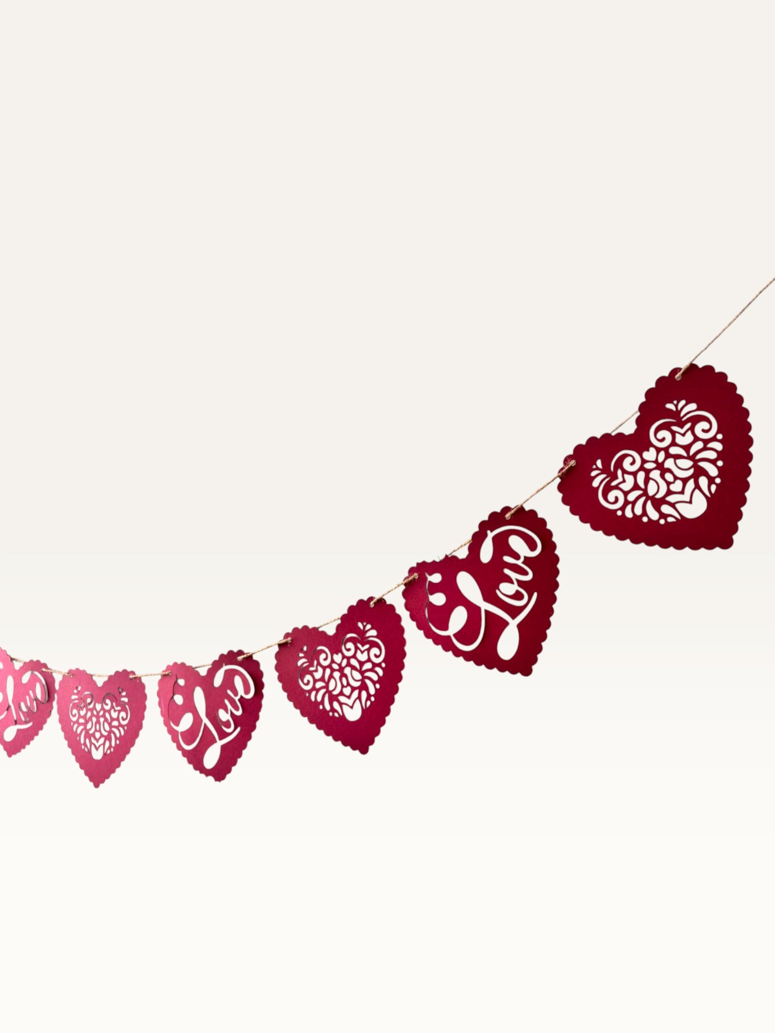 Paper Party Studio red heart bunting with scalloped edges, floral cut-outs, and cursive Love script for romantic decor.
