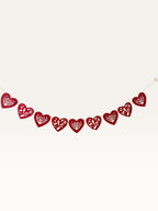 Paper Party Studio red heart bunting with intricate floral cut-outs and cursive Love script for romantic decor.