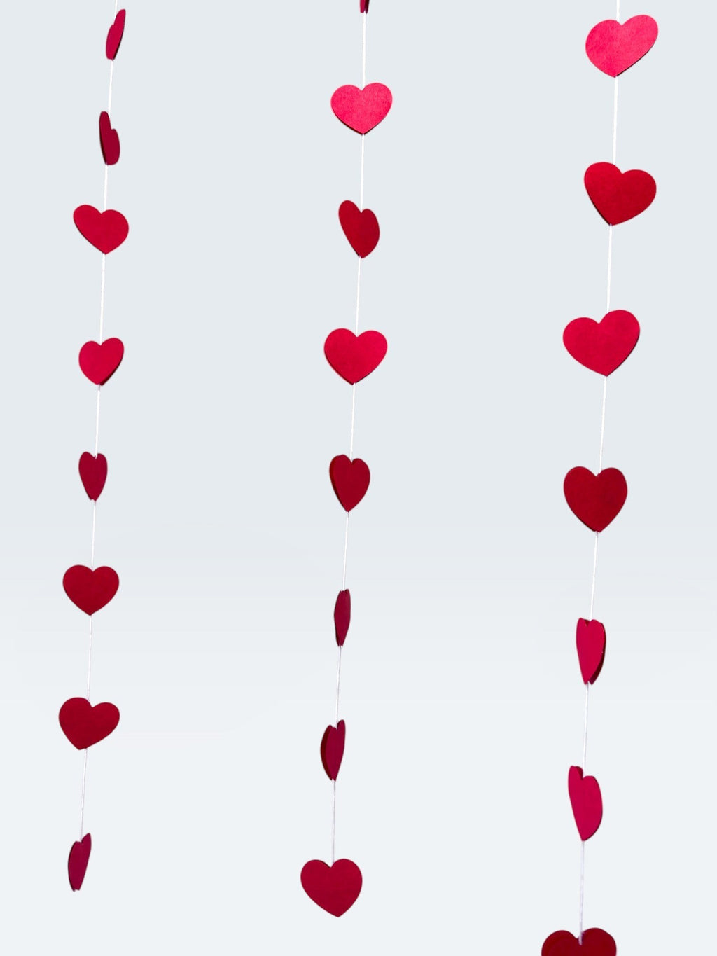 Paper Party Studio red heart garland, set of 10 strings with mini heart cut-outs, perfect for Valentine's Day or weddings.