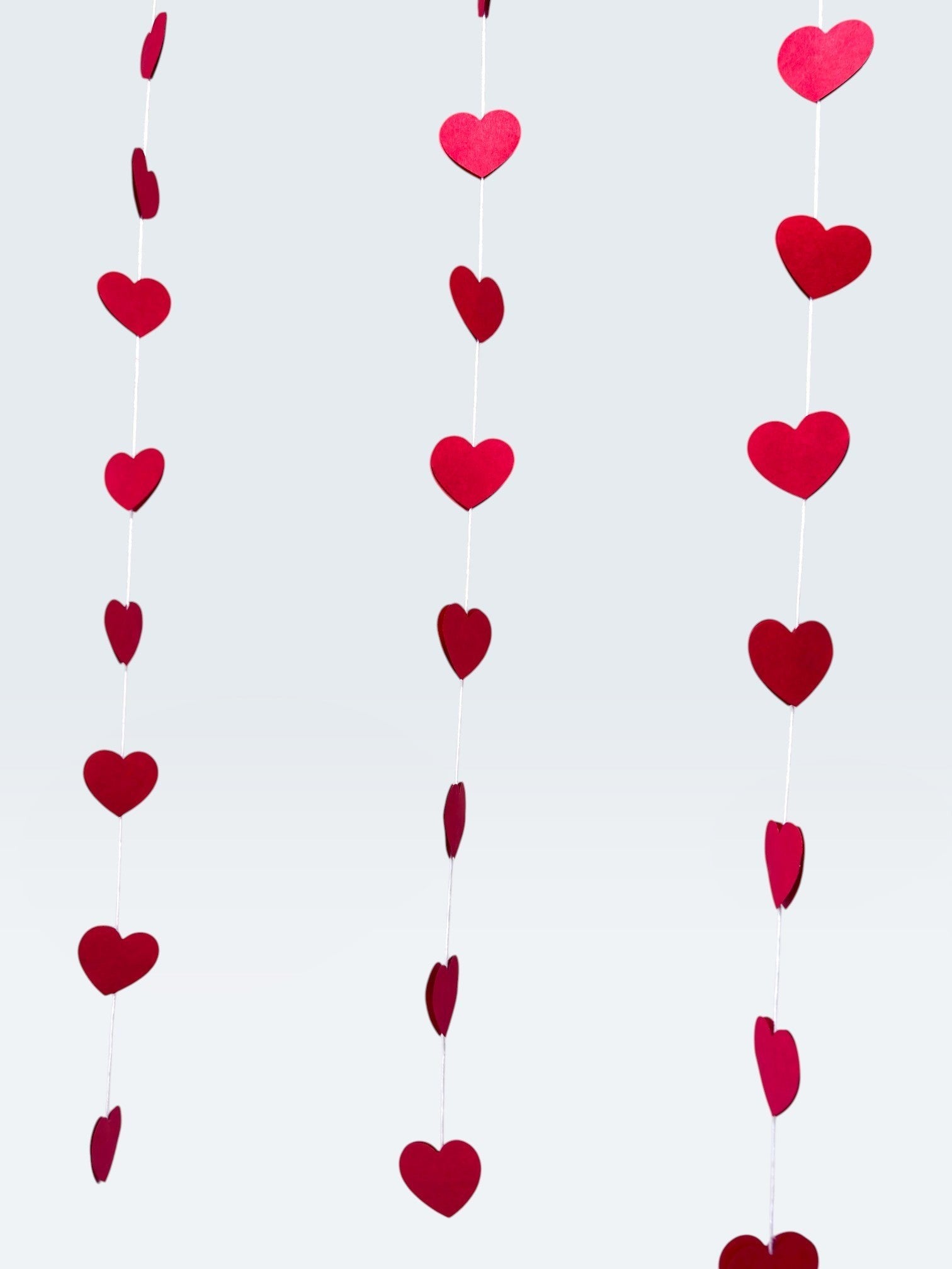 Paper Party Studio red heart garland, set of 10 strings with mini heart cut-outs, perfect for Valentine's Day or weddings.