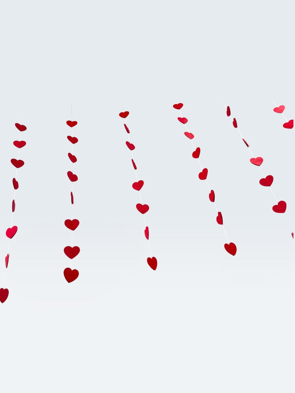 Paper Party Studio red heart garland, a set of 10 strings with mini heart cut-outs, perfect for Valentine's Day or weddings.