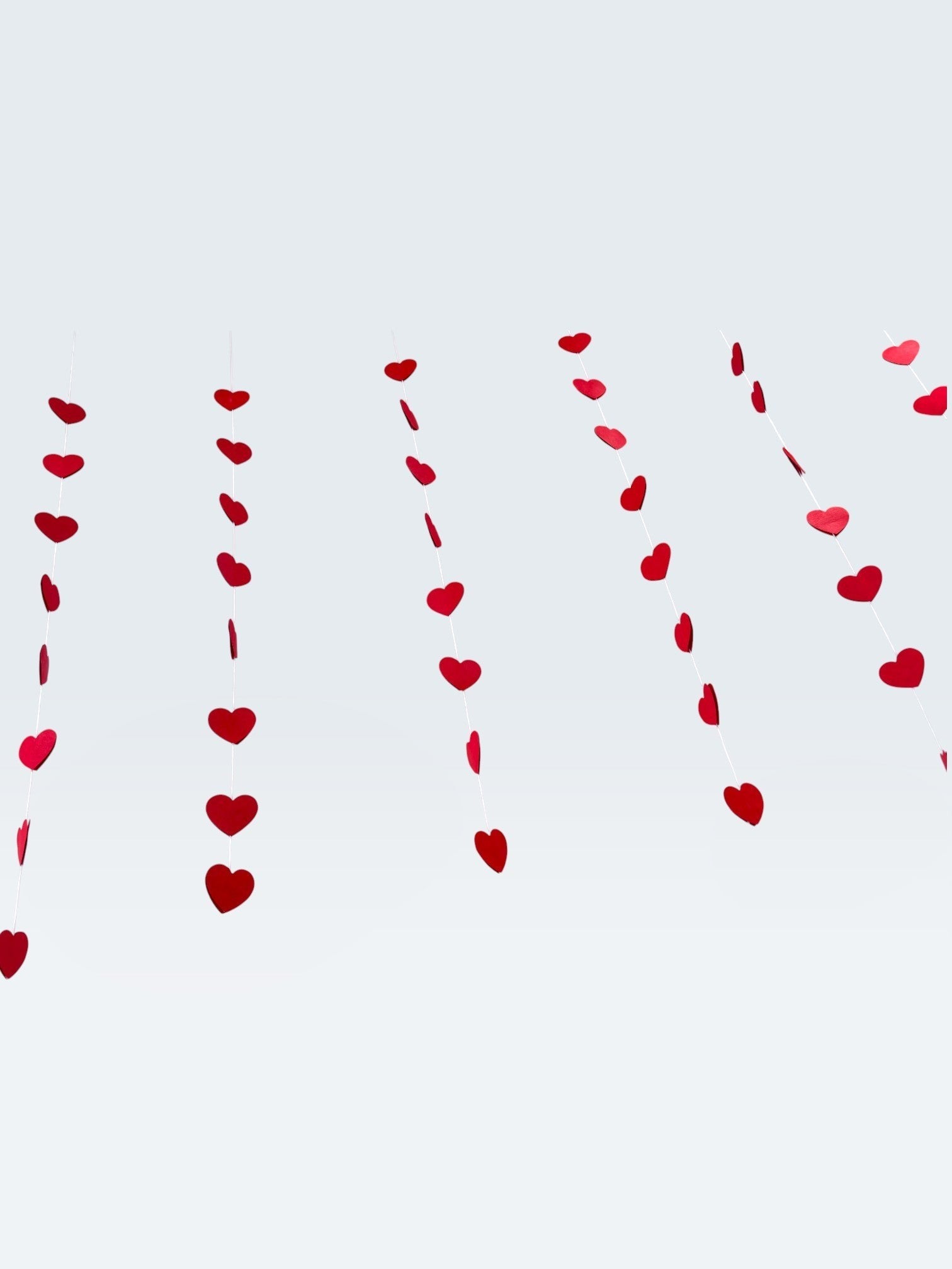 Paper Party Studio red heart garland, a set of 10 strings with mini heart cut-outs, perfect for Valentine's Day or weddings.