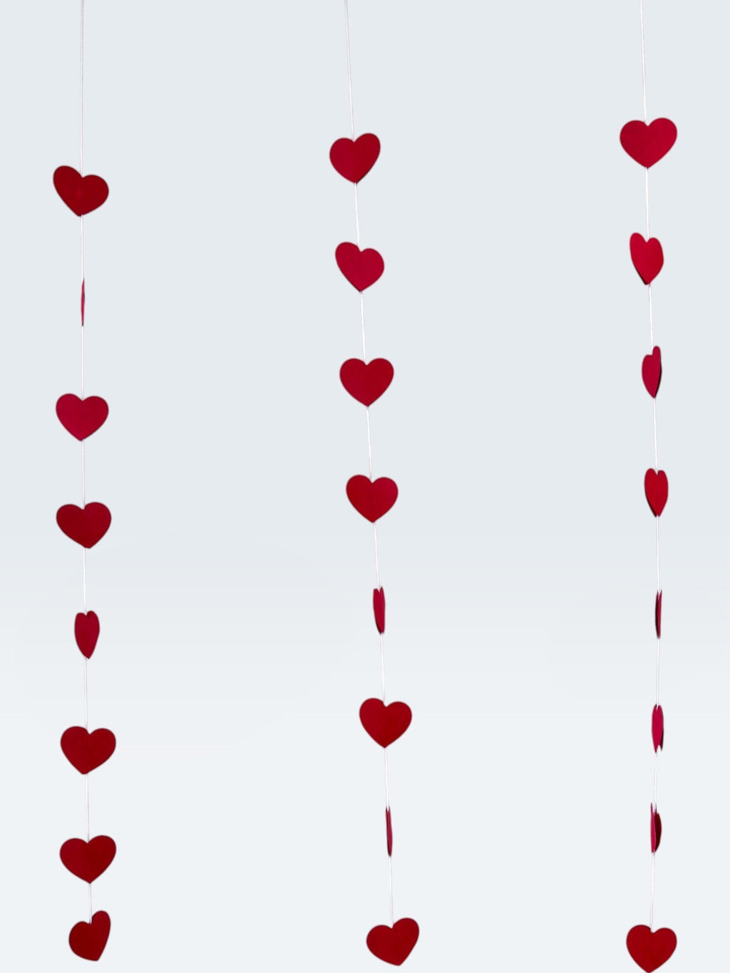 Paper Party Studio red heart garland, 10 strings of mini red hearts on white thread, romantic backdrop for Valentine's Day or weddings.