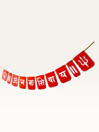 Paper Party Studio red paper banner with white Om Namah Shivaya mantra and trishul motifs for festive pooja decor.