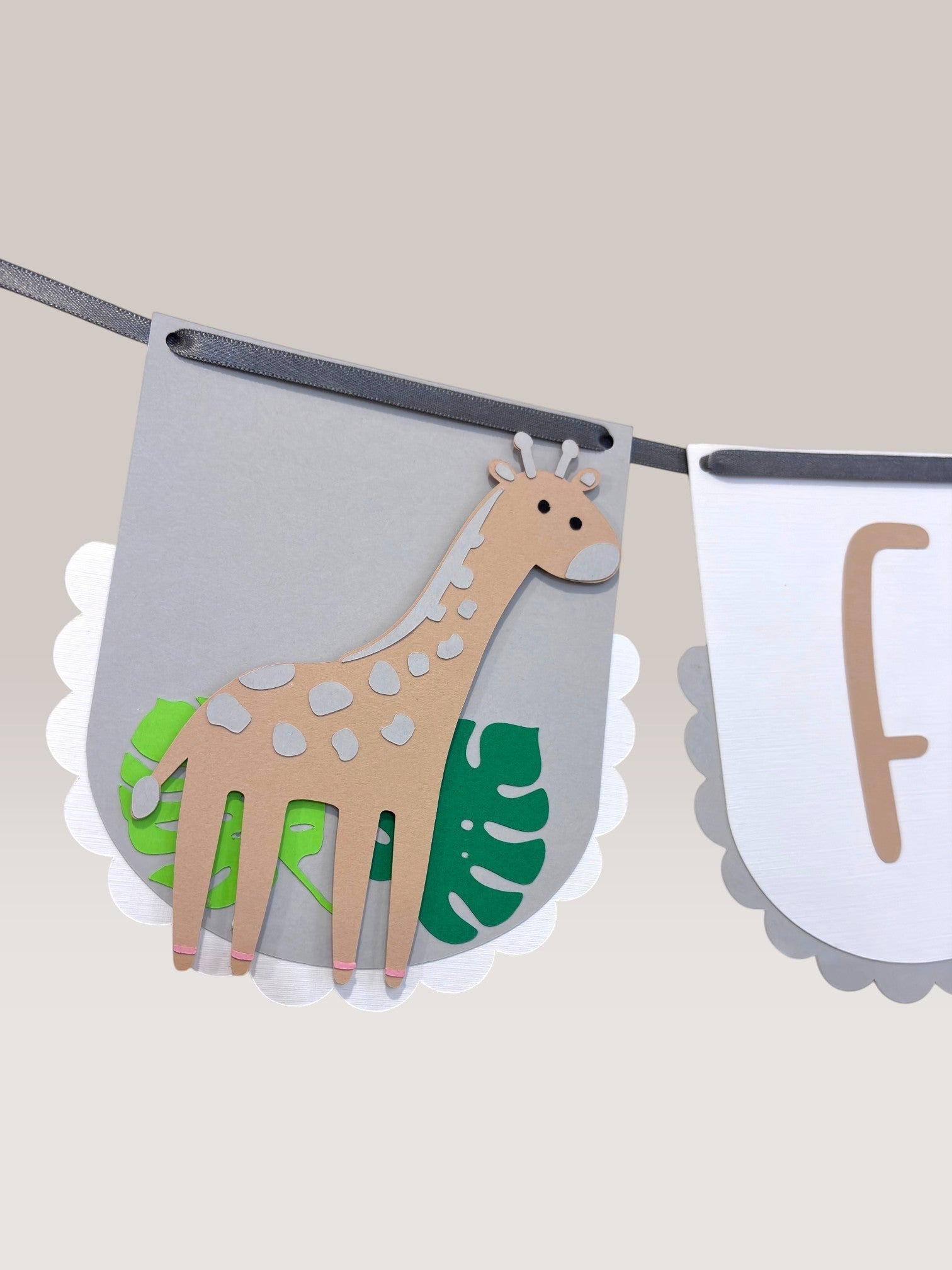 Paper Party Studio Safari Birthday Banner with giraffe, tiger, and kraft lettering. White scalloped flags with jungle leaves.