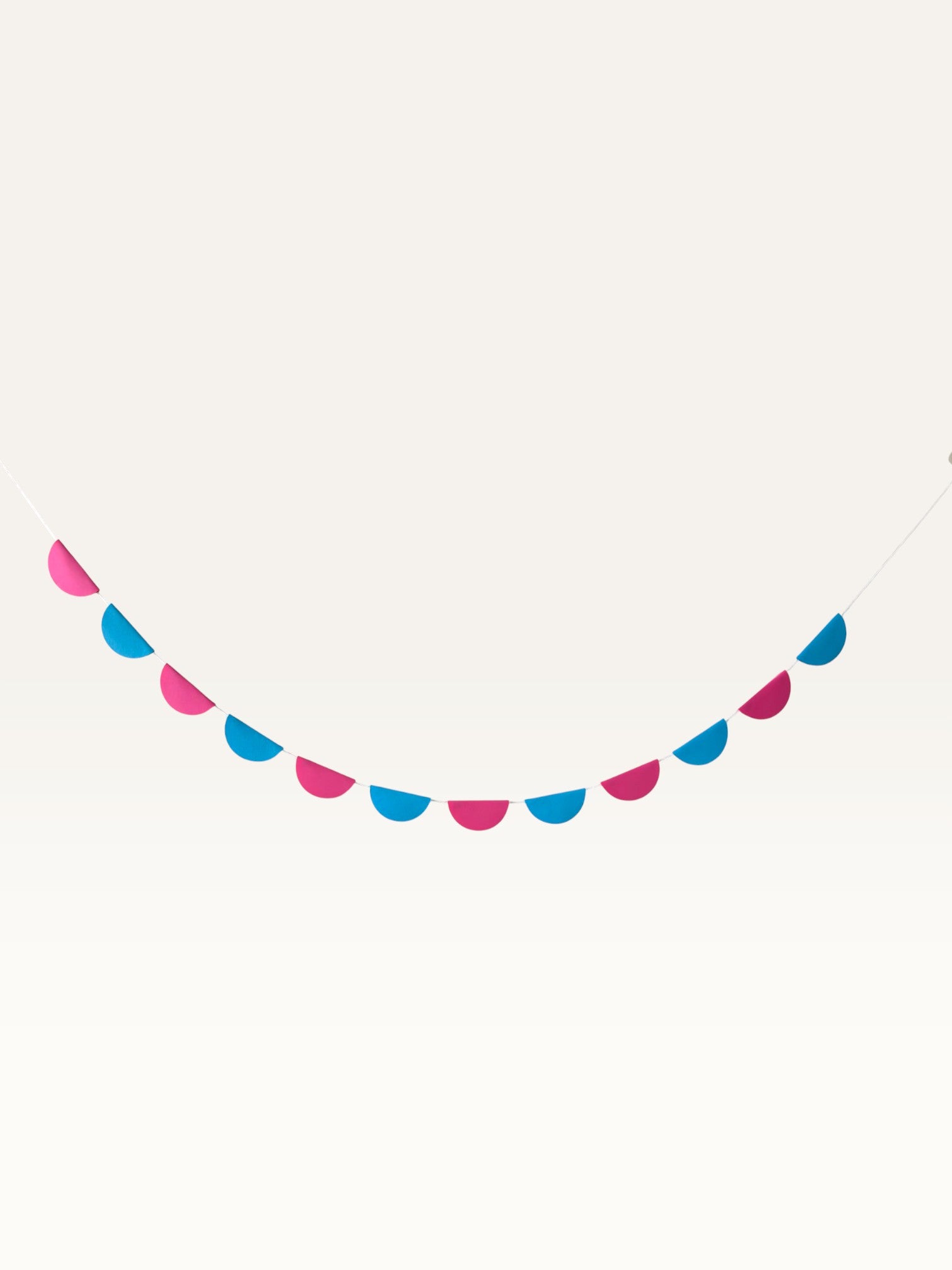 Paper Party Studio scallop garland featuring alternating pink and blue paper half-circles on a string for party decor.