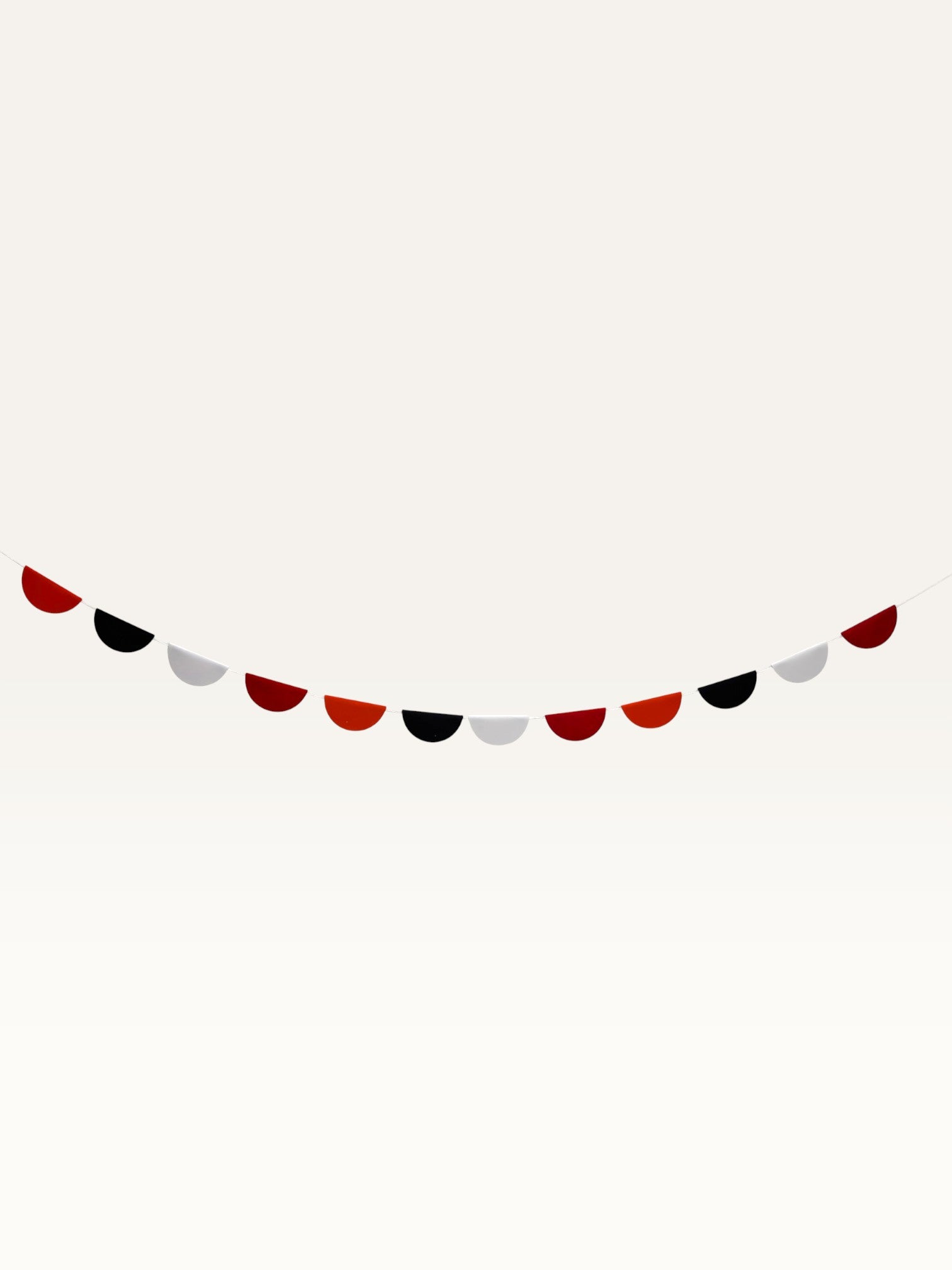 Paper Party Studio scallop garland featuring alternating red, black, and white paper half-circles on a string.