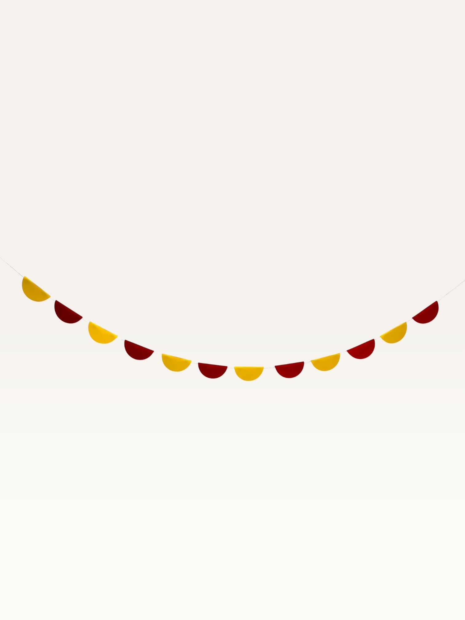 Paper Party Studio scallop garland with alternating yellow and deep red paper half-circles on a string