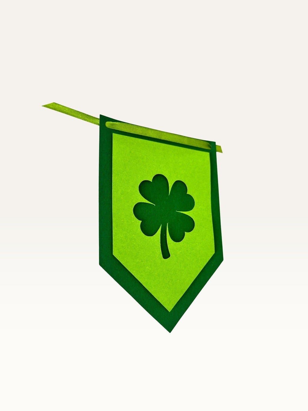 Paper Party Studio lucky shamrock bunting featuring layered green cardstock shield flags with clover cut-outs.