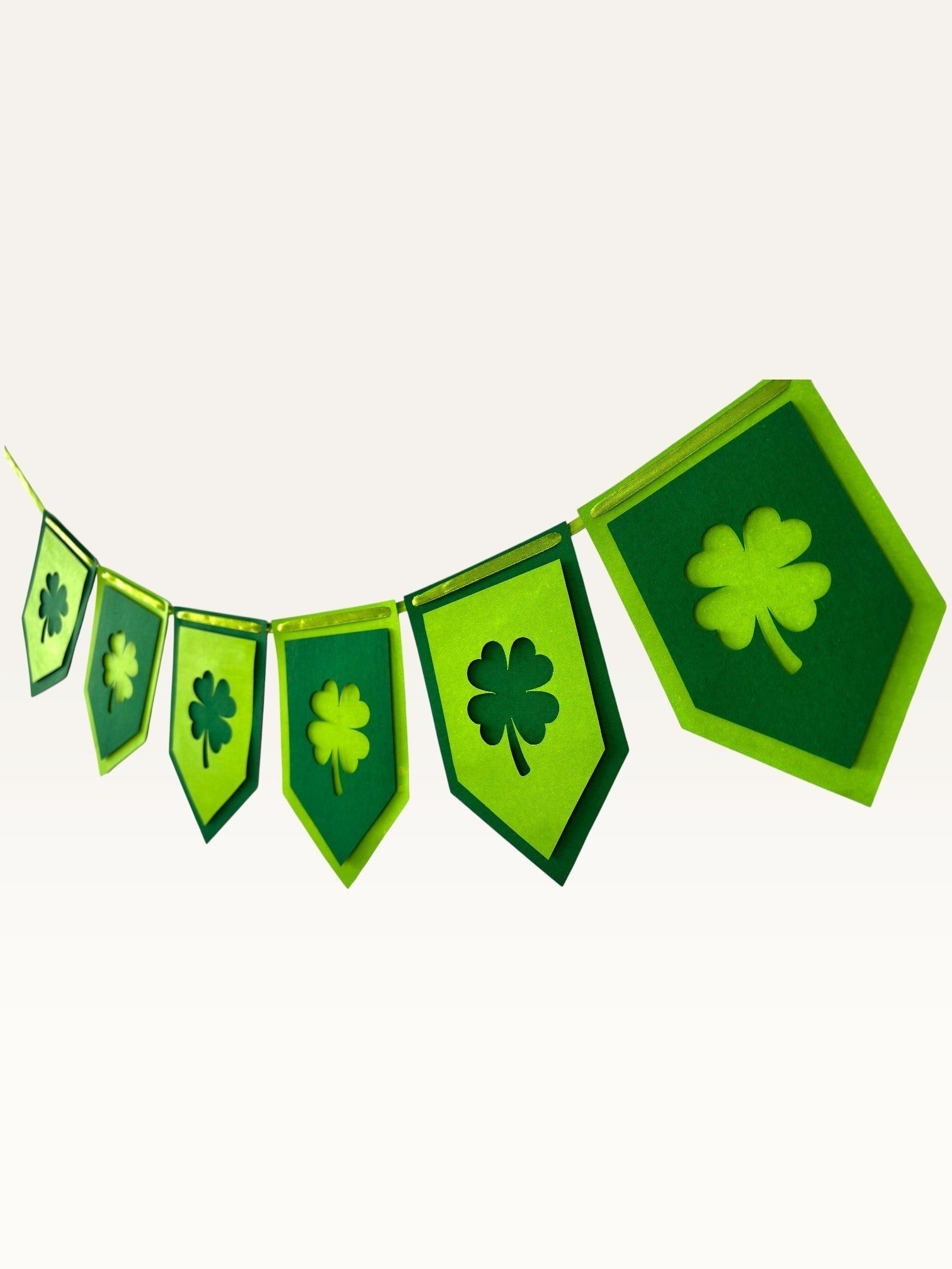 Paper Party Studio green shamrock bunting with layered clover cut-out paper flags for St. Patrick's Day decor.