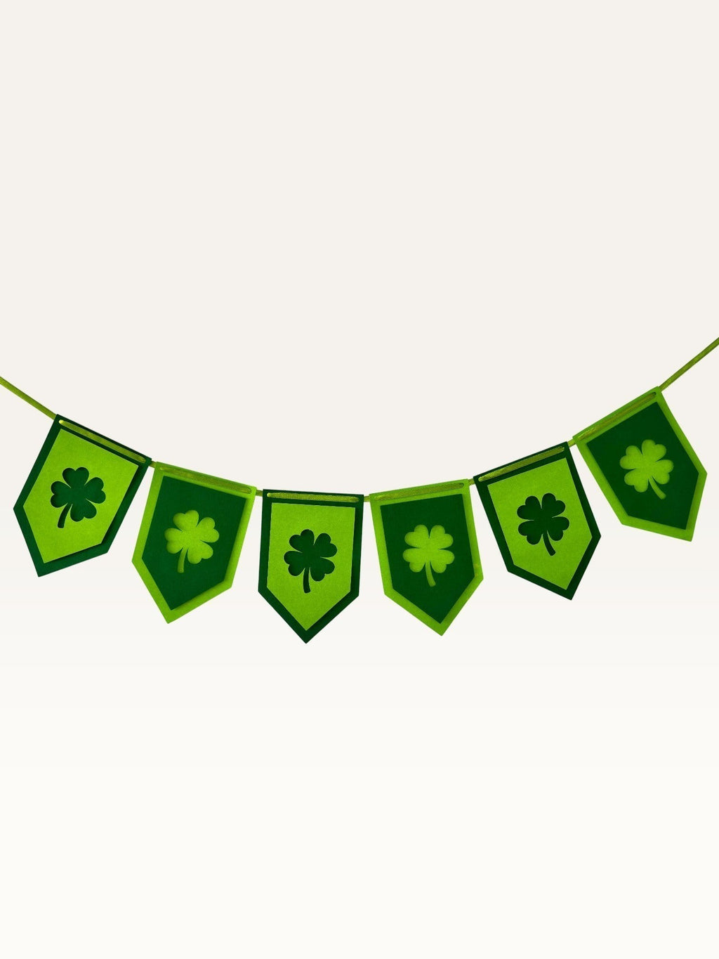 Paper Party Studio green shamrock bunting with layered clover cut-out paper flags for St. Patrick's Day decor.