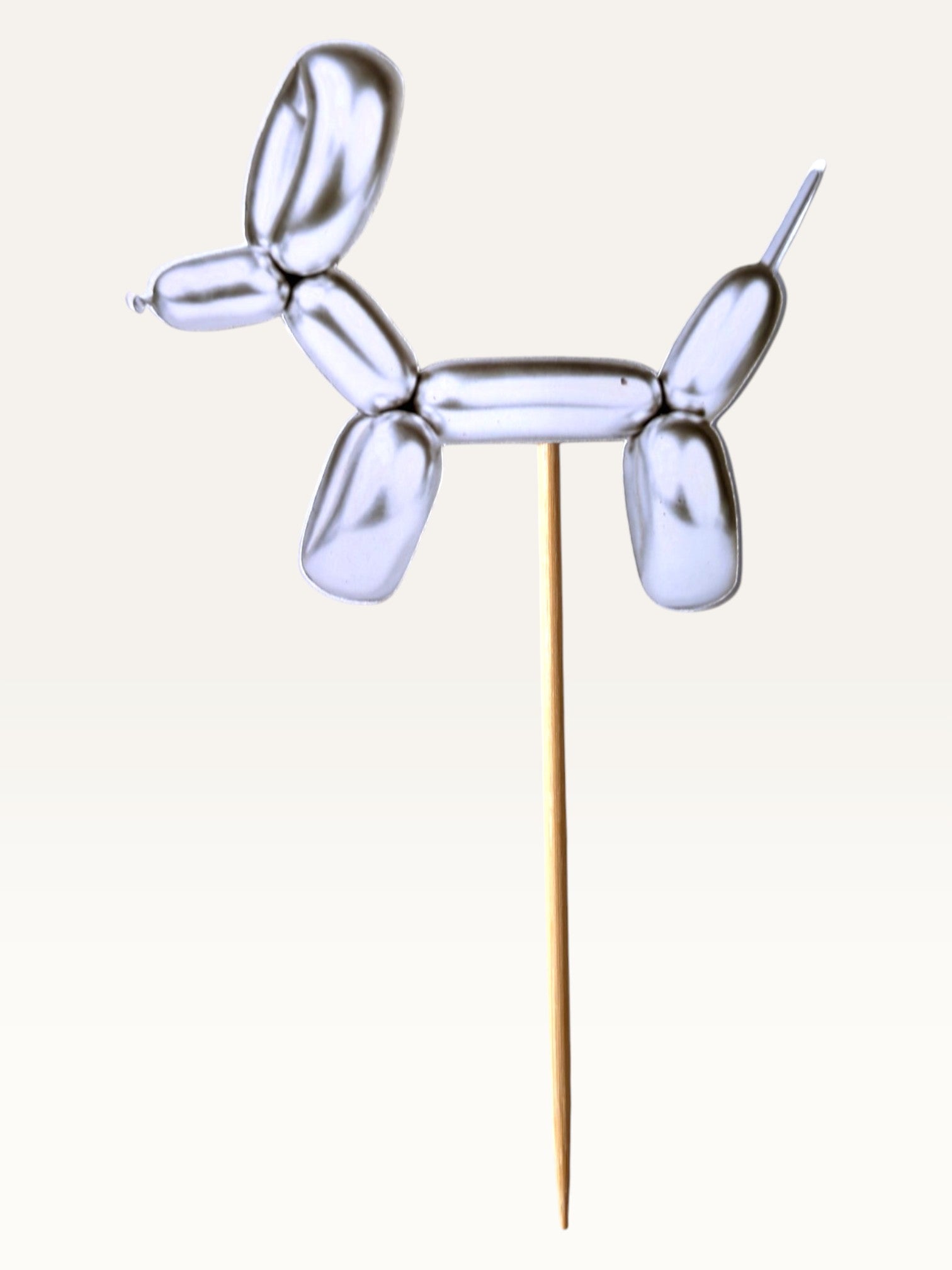 Paper Party Studio silver foil balloon dog cupcake topper on a bamboo stick, double-sided metallic paper design.