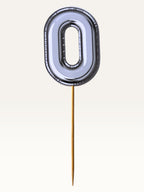 Paper Party Studio silver foil number zero cake topper with a sleek chrome finish on a bamboo stick