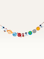 Paper Party Studio space adventure garland featuring paper astronauts, rockets, and planets strung on a red cord.