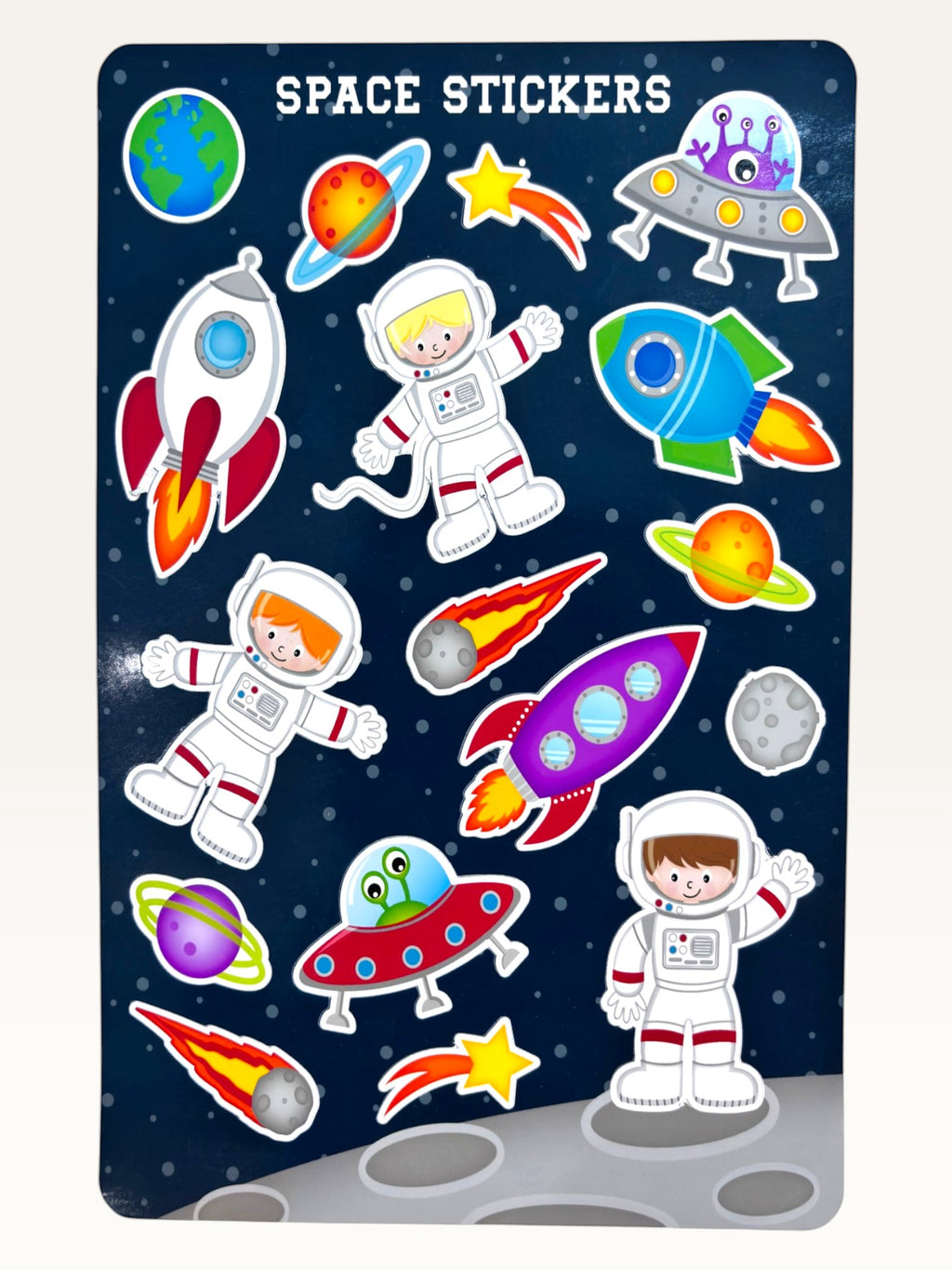 Paper Party Studio glossy sticker sheet featuring rockets, astronauts, planets, and aliens on a deep blue starry background